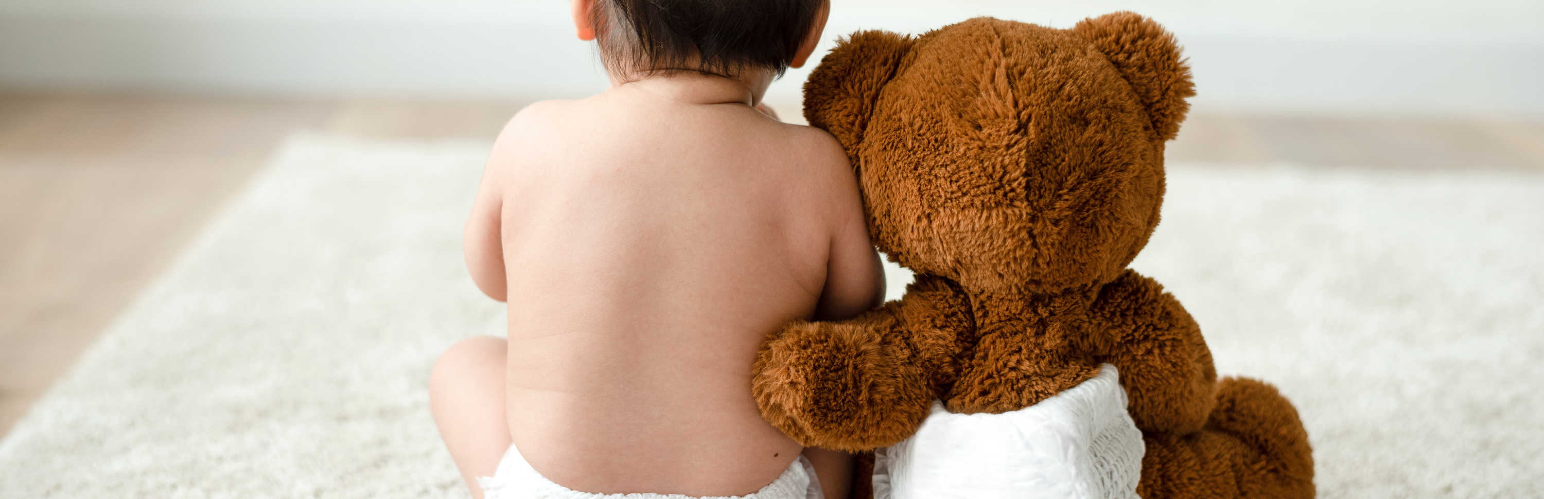 Gyerek és kismaci Plüssmaci átöleli a babát